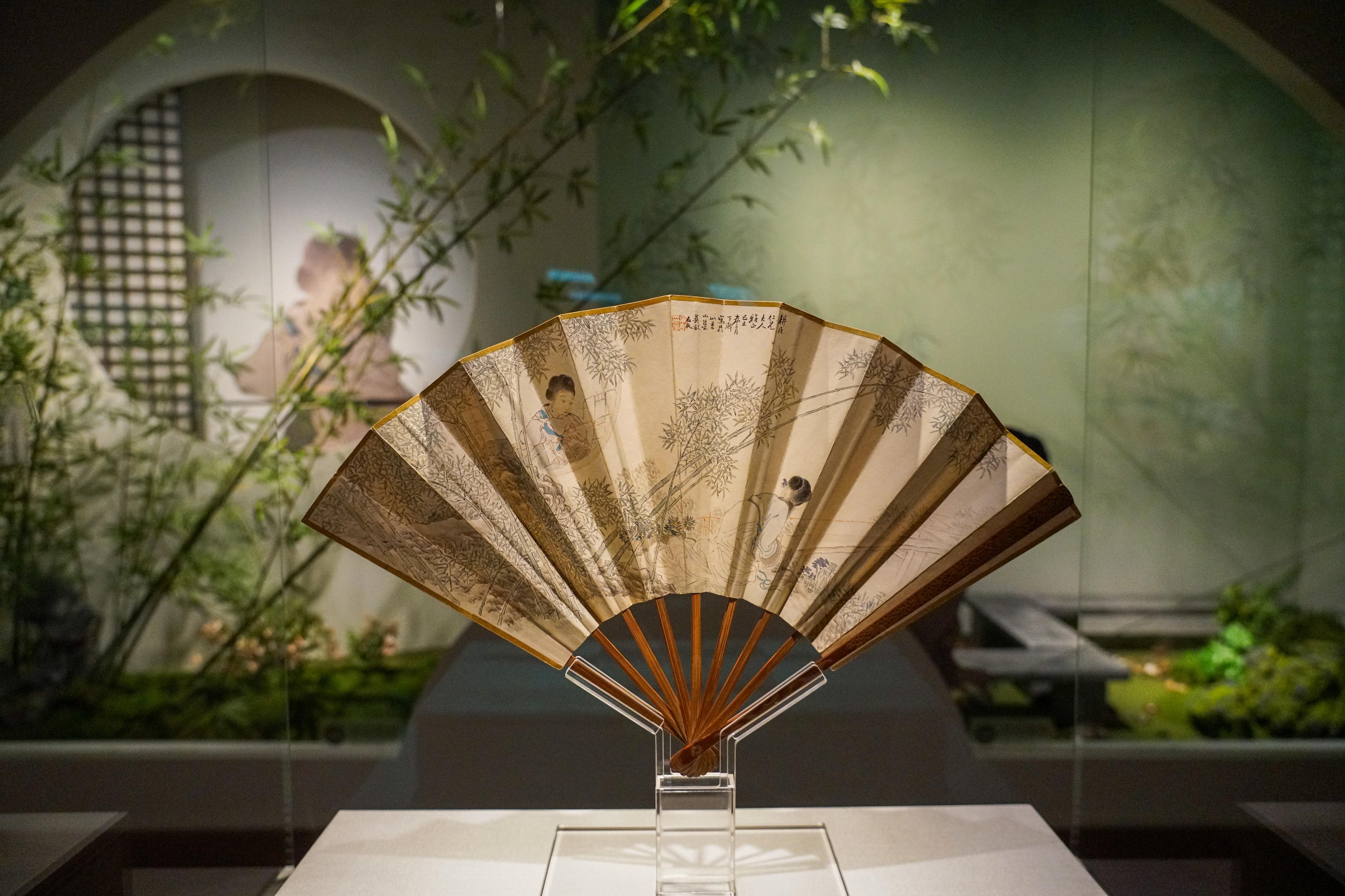 A traditional Chinese folding fan with hand-painted flowers, fully open