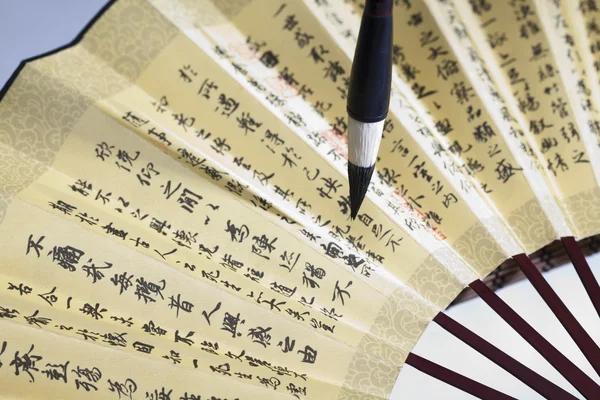 Traditional Chinese fan with painted landscape and calligraphy
